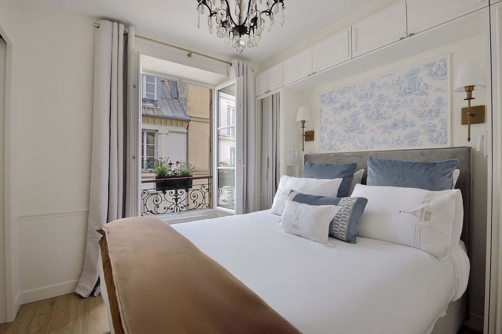 Comfortable bedroom with large window overlooking a charming view.