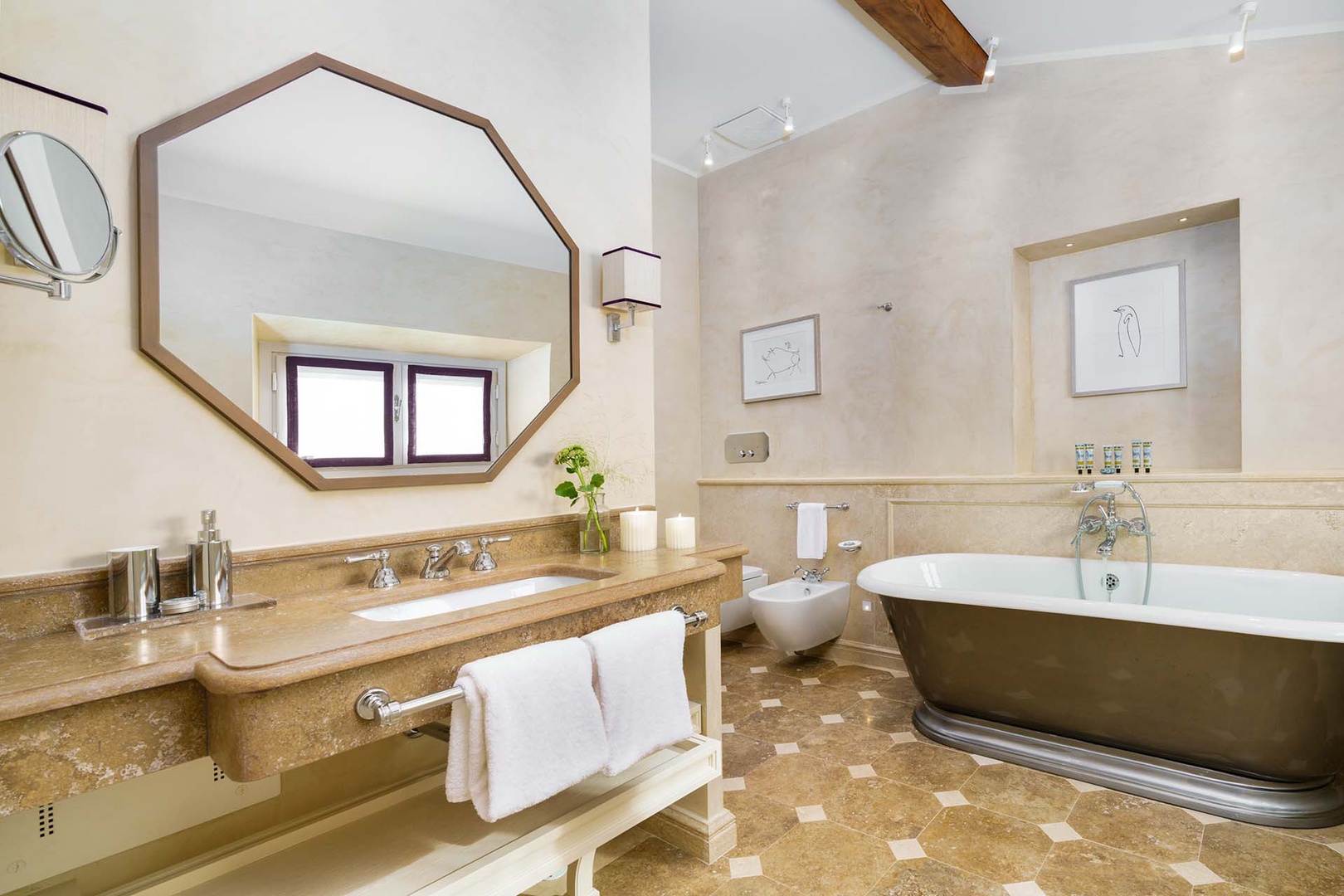 En suite bathroom in bedroom 2 is a luxury space with rolltop bathtub as well as shower, toilet, and sink.