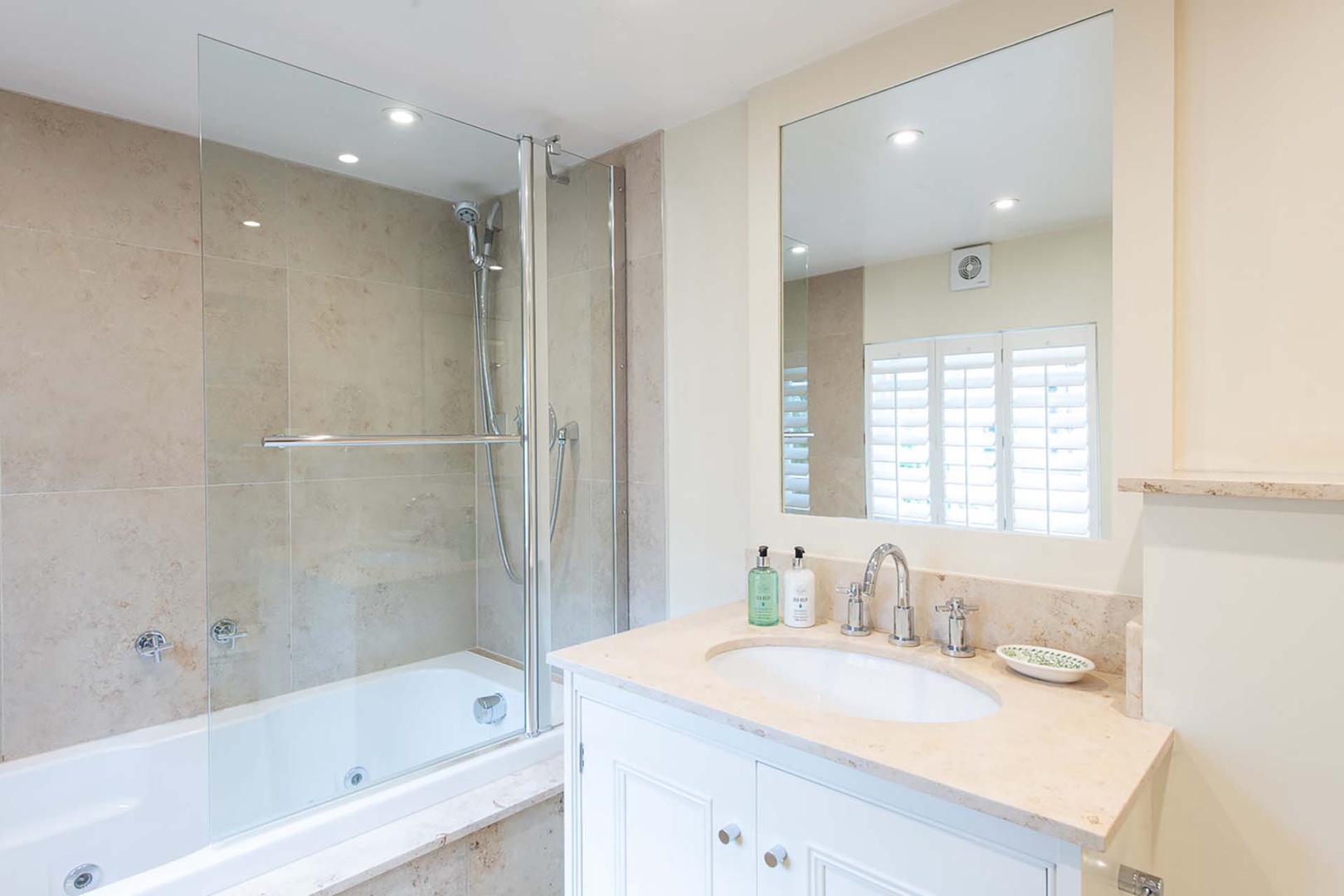 Spacious bathroom with toilet, sink and bathtub/ shower combo.