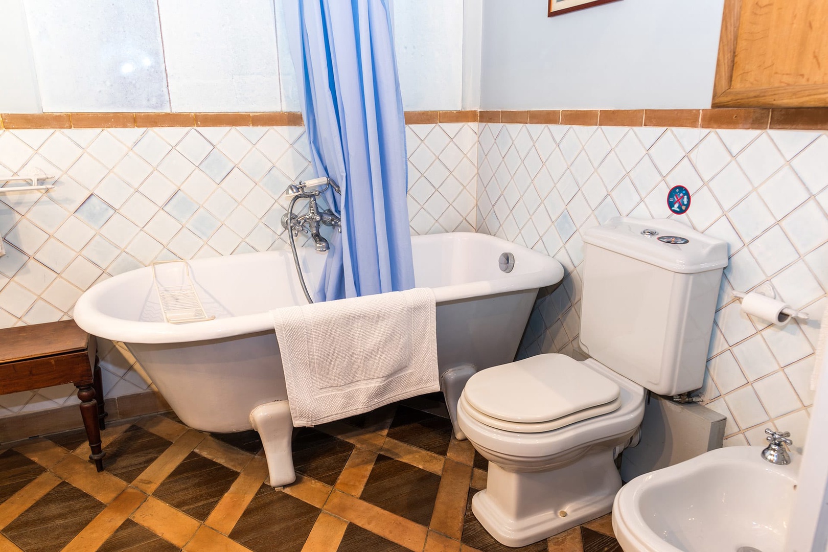 The bathroom has a bathtub fitted with a handheld showerhead, toilet and bidet.