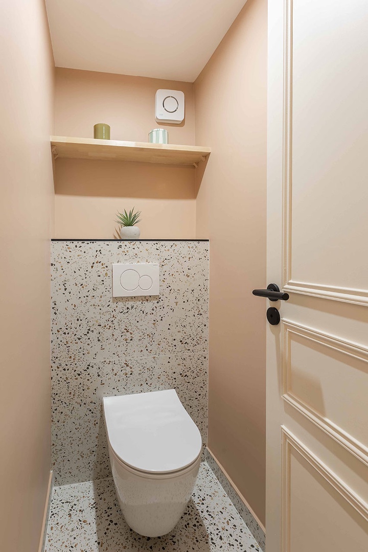 Powder room with toilet is located between bedroom and living room.