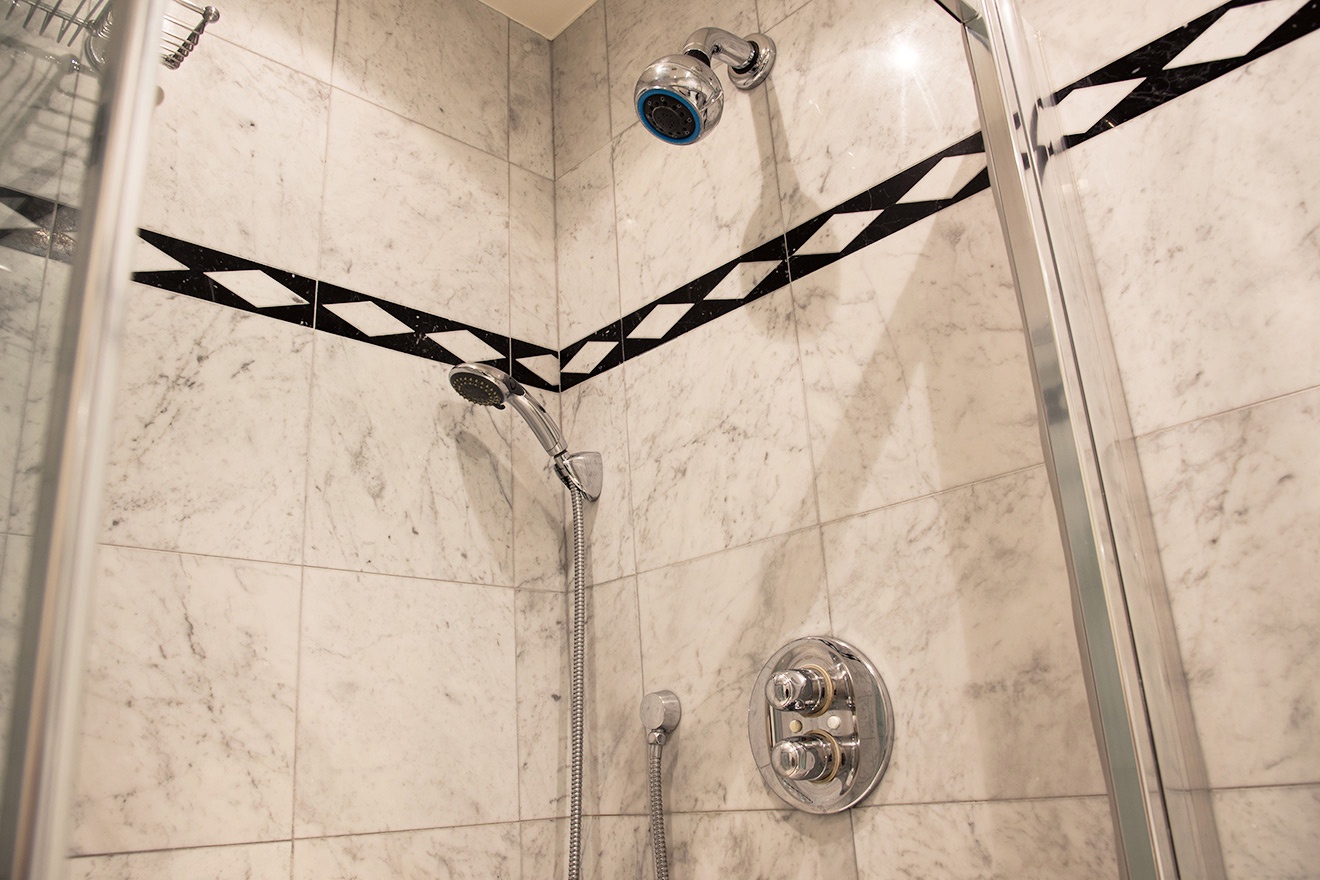 The large shower in bathroom 1 features both fixed and flexible shower heads.