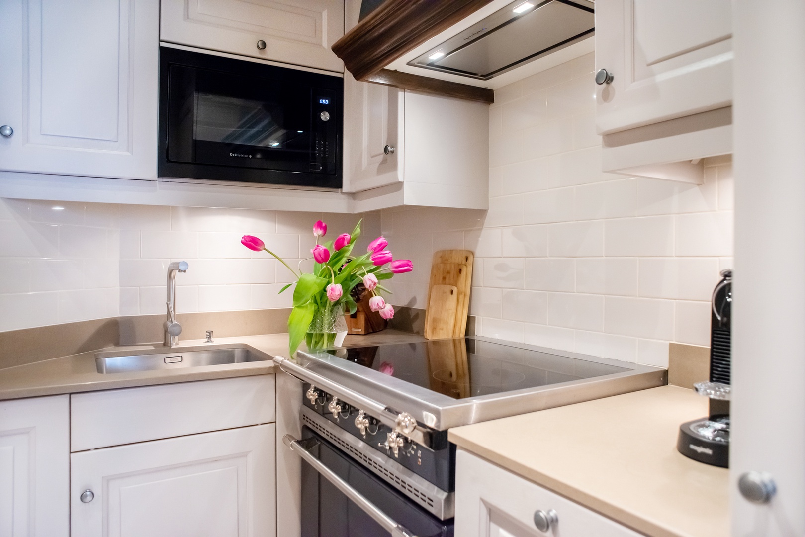 Enjoy preparing meals in this modern kitchen with a premium Lacanche range.