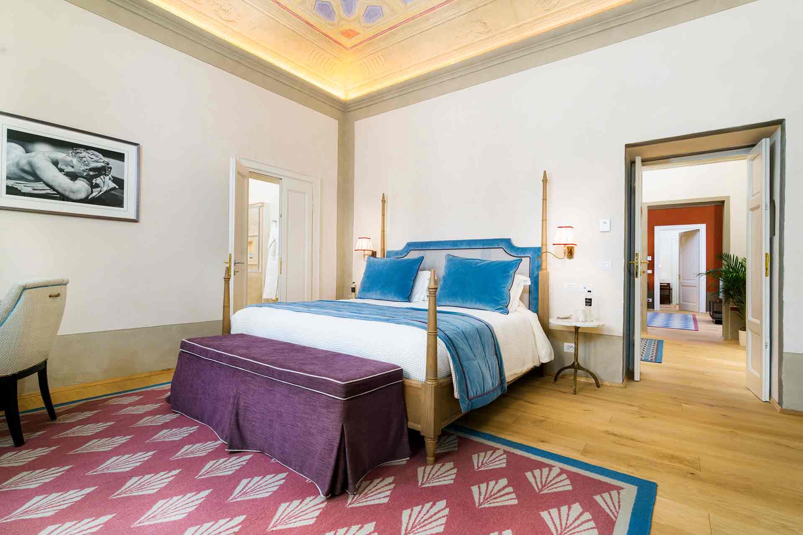 Bedroom 1 features a stately four-poster bed dressed in plush blue linens.