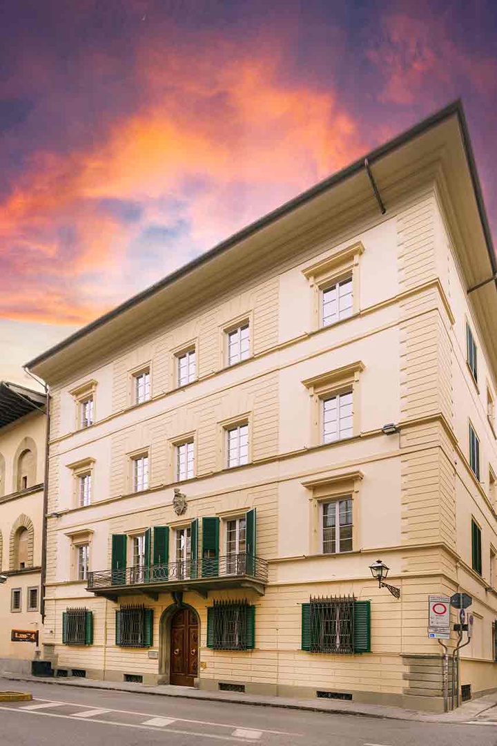 The property is set within an elegant historic building featuring classic architecture with decorative window frames and shutters.