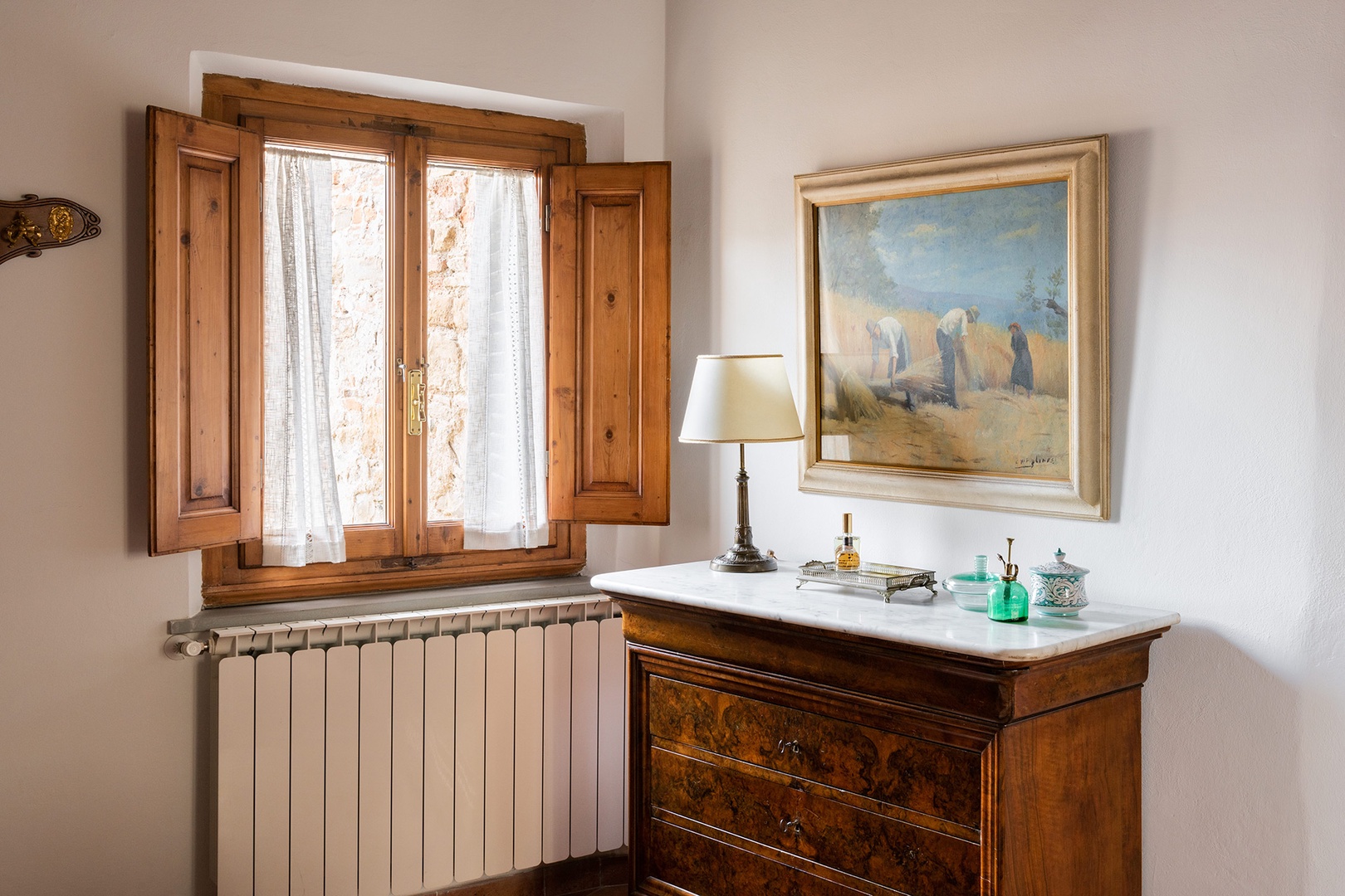 Classic Tuscan art above marble-topped bureau in the bedroom.