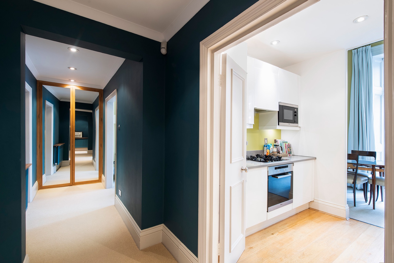 Hallway with stunning deep blue walls leads to bedrooms