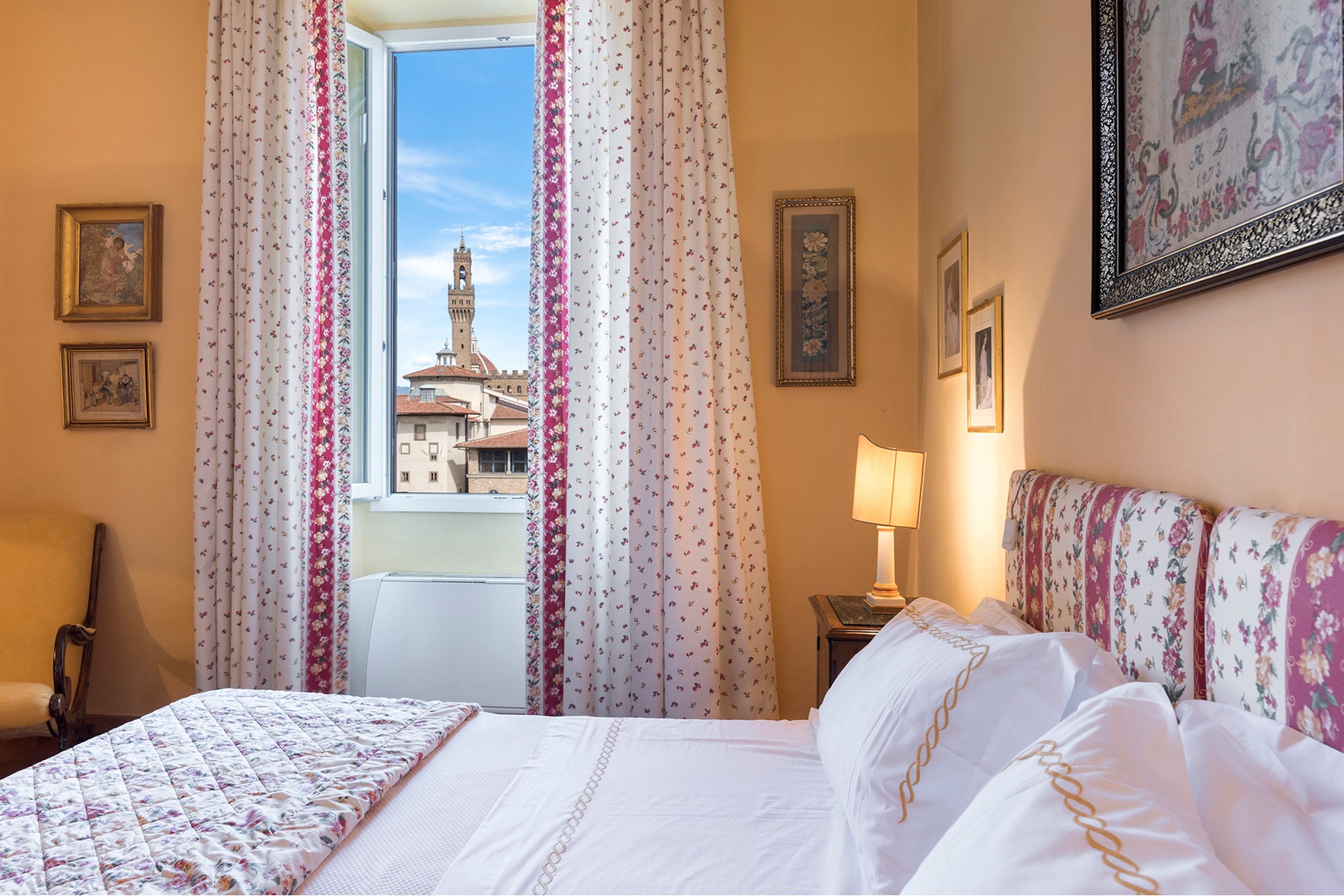 Sunny bedroom 1 has gorgeous Arno River views. See the bell tower of Palazzo Vecchio in this photo.