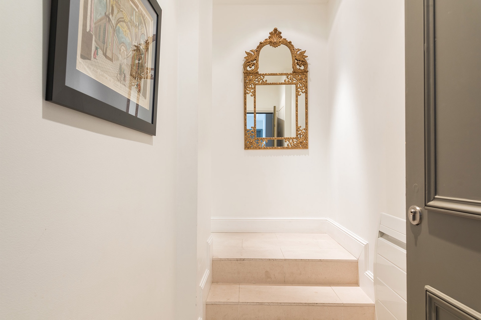 A Belle Epoque-styled mirror decorates the entryway.