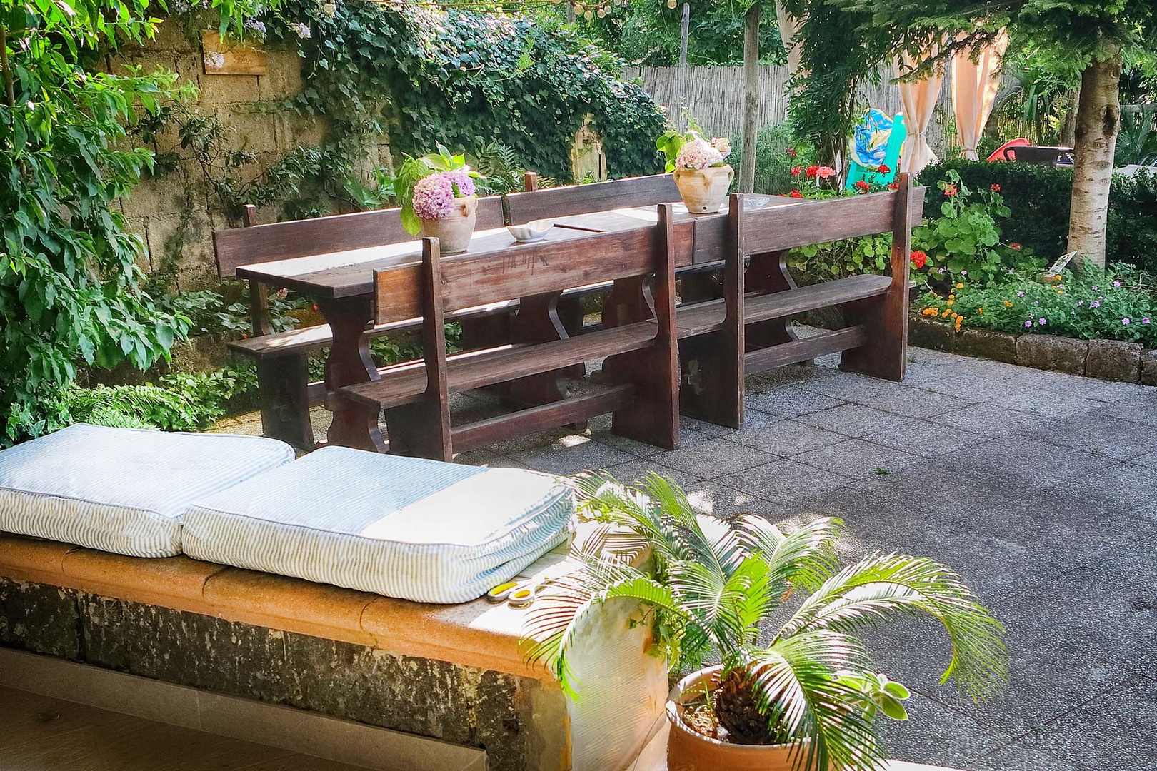 Rustic table is an additional outdoor dining space.