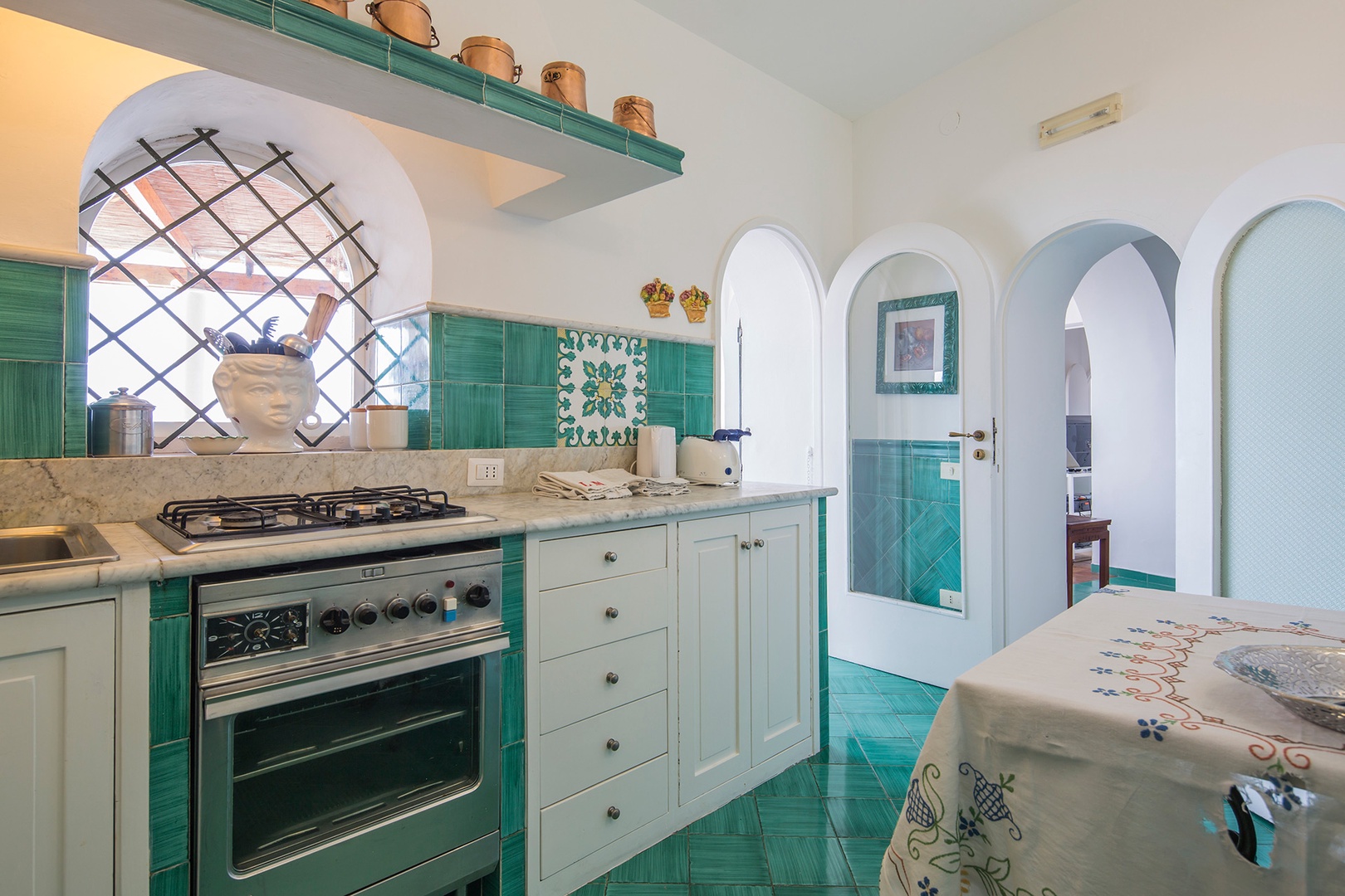 Pretty turquoise tiles carry throughout the dining and fully equipped kitchen.