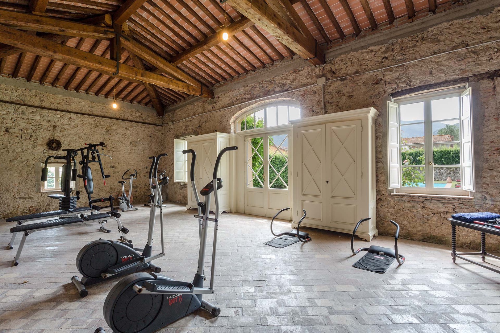 The gym has large windows overlooking the pool