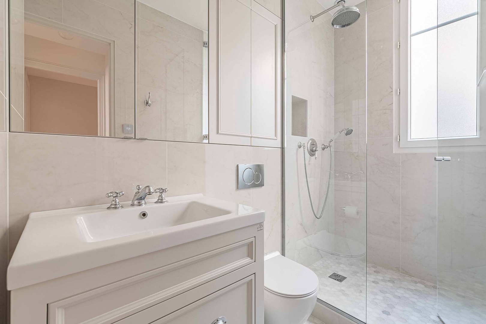 Bathroom 1 with large shower, toilet and sink is en suite to bedroom 1.