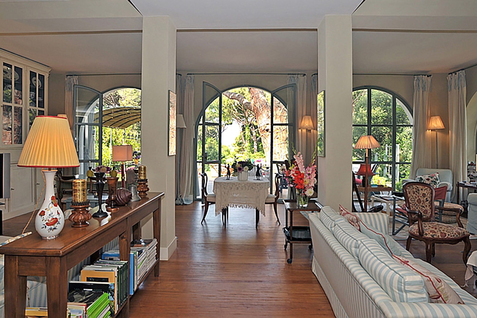 Gracefully arched windows on two sides of the living room bring the outside in.