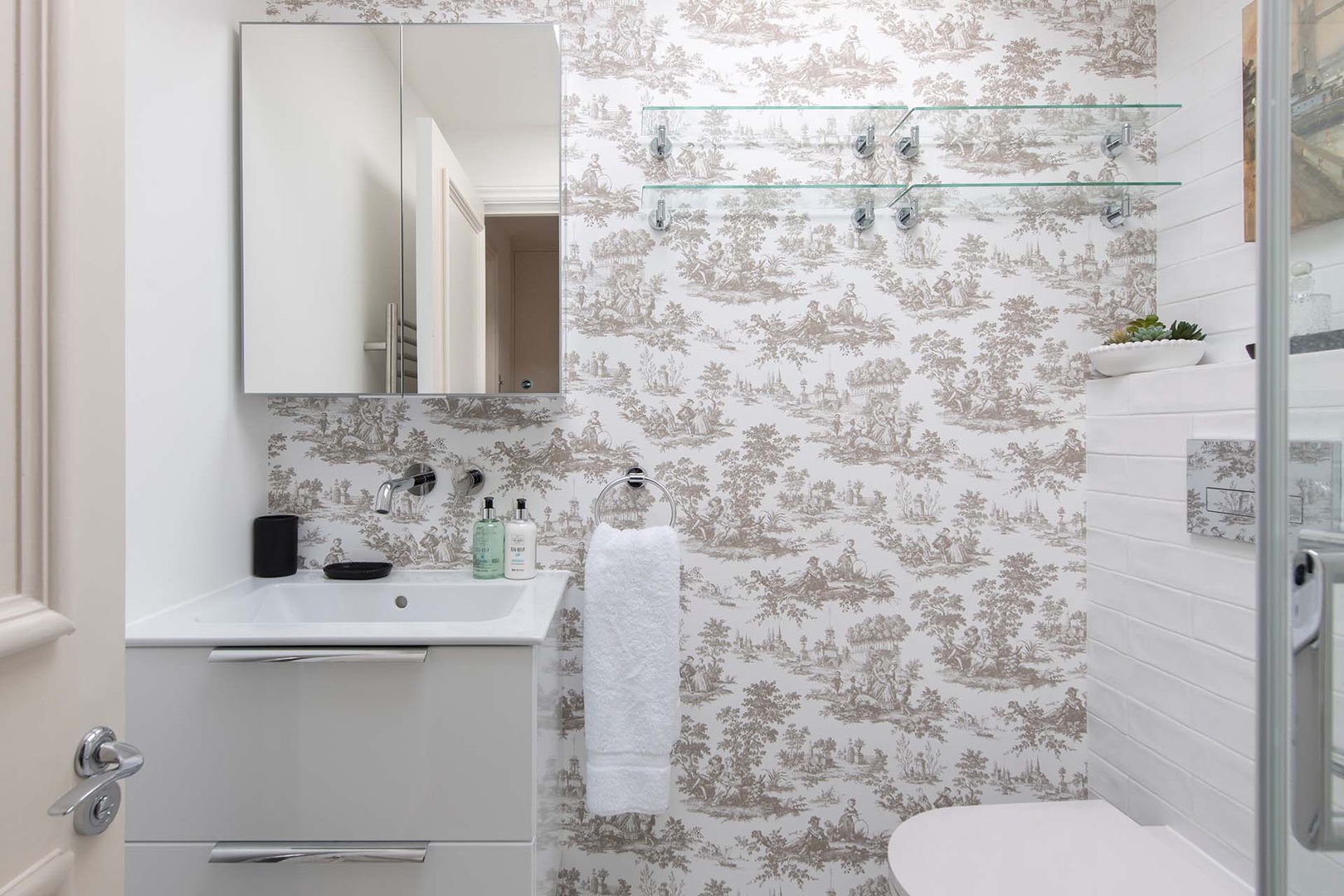 Bathroom features a shower with rainfall and flexible showerhead.