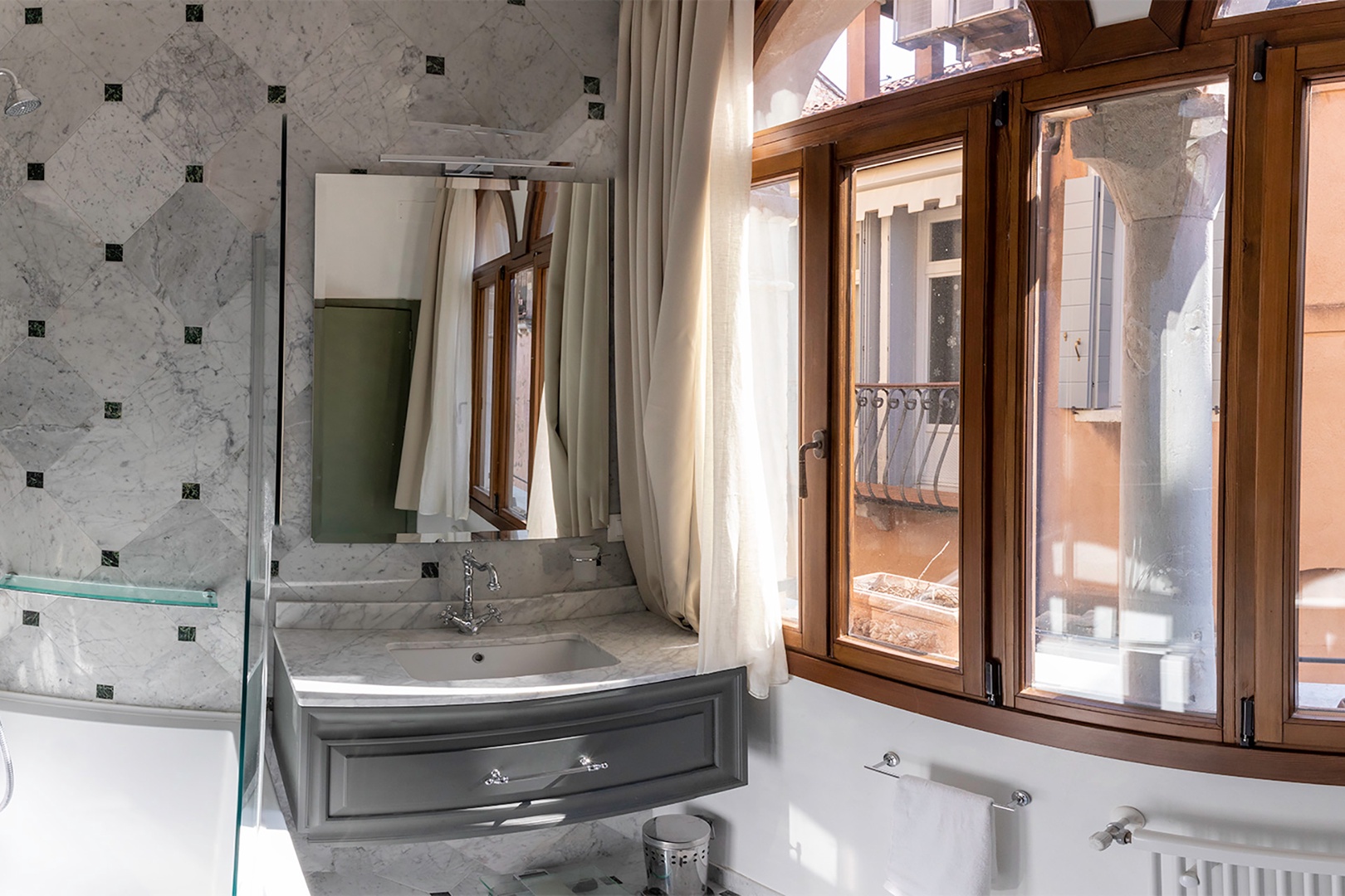 Marble-lined bathroom en suite to bedroom 1