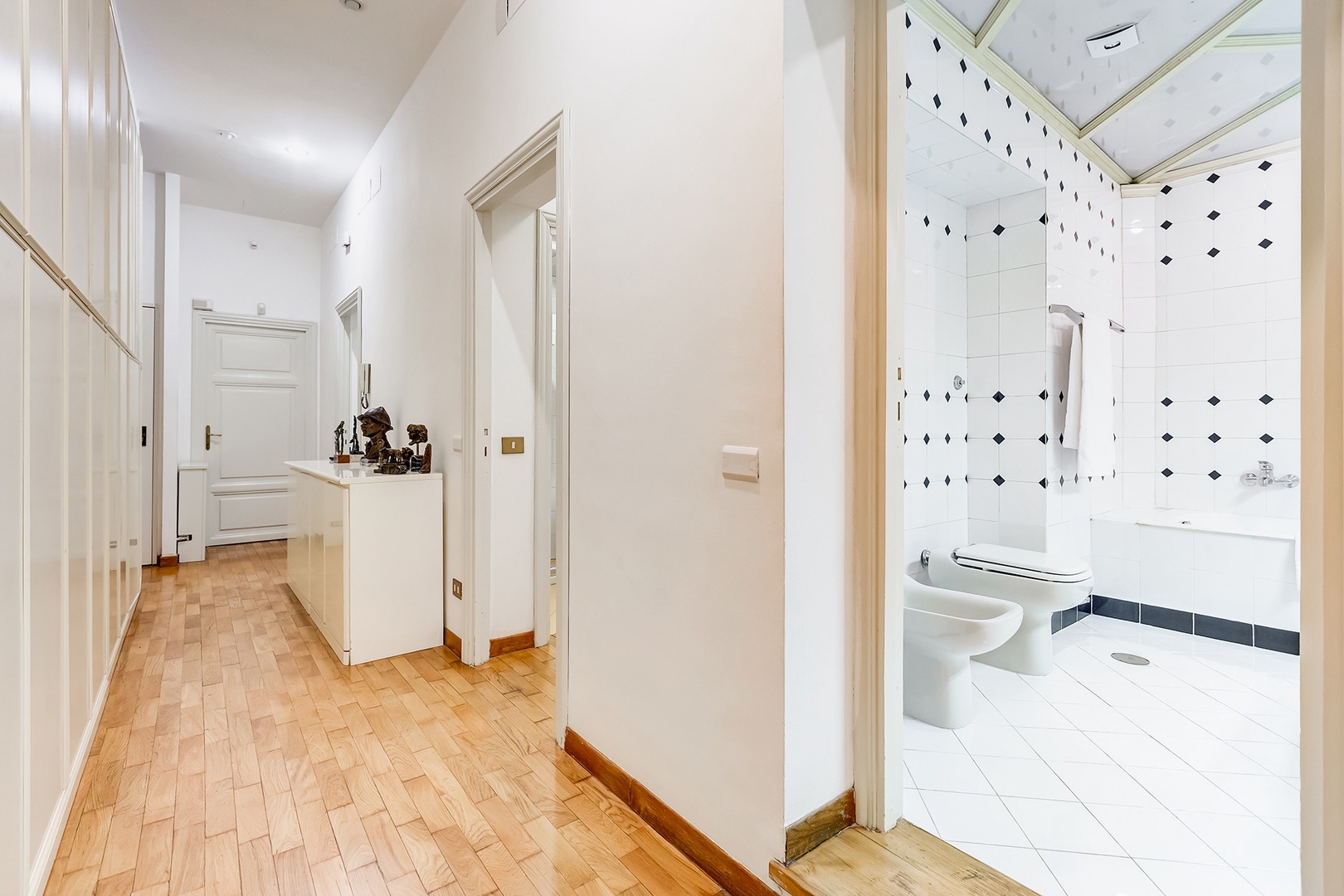 Hallway off the main entrance leads to more bedrooms and baths