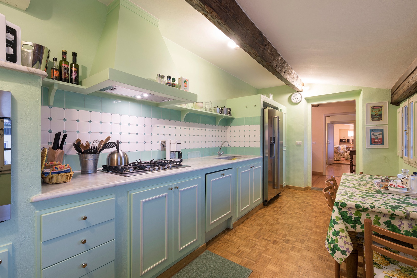 Kitchen is bright and cheerful and fully equipped with pots, pans, dishes.