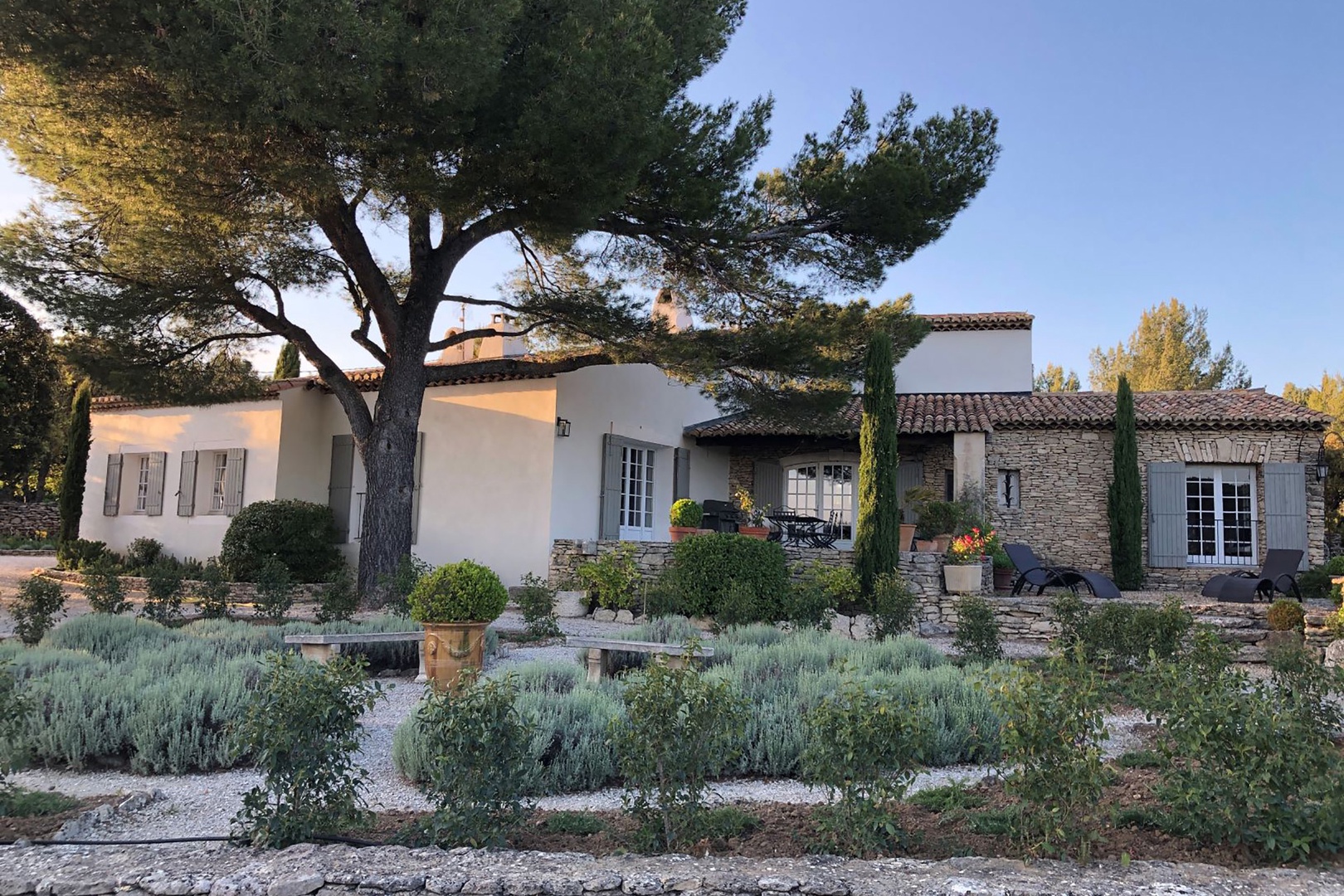 Serene stone and stucco house surrounded by gardens