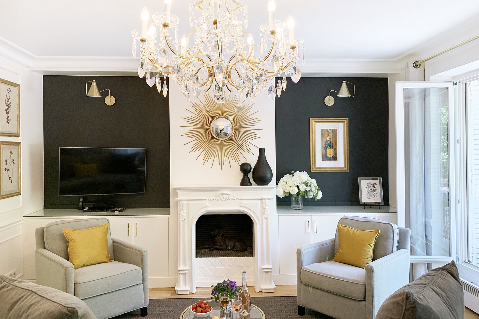 The decorative fireplace mantle and striking sunburst mirror give the room a chic Parisian feel.