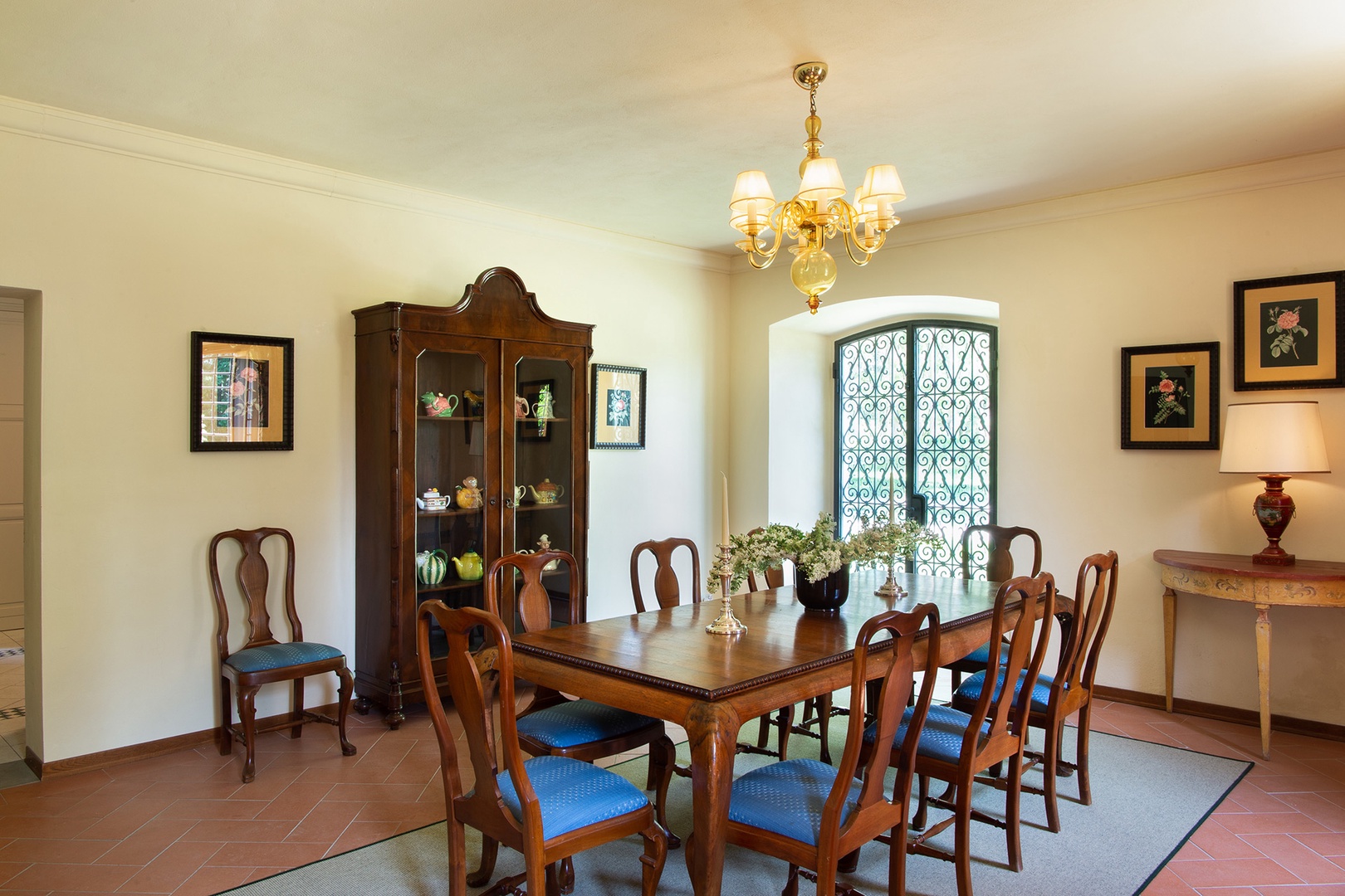 The elegant dining area opens onto the gardens and pool area through French doors.