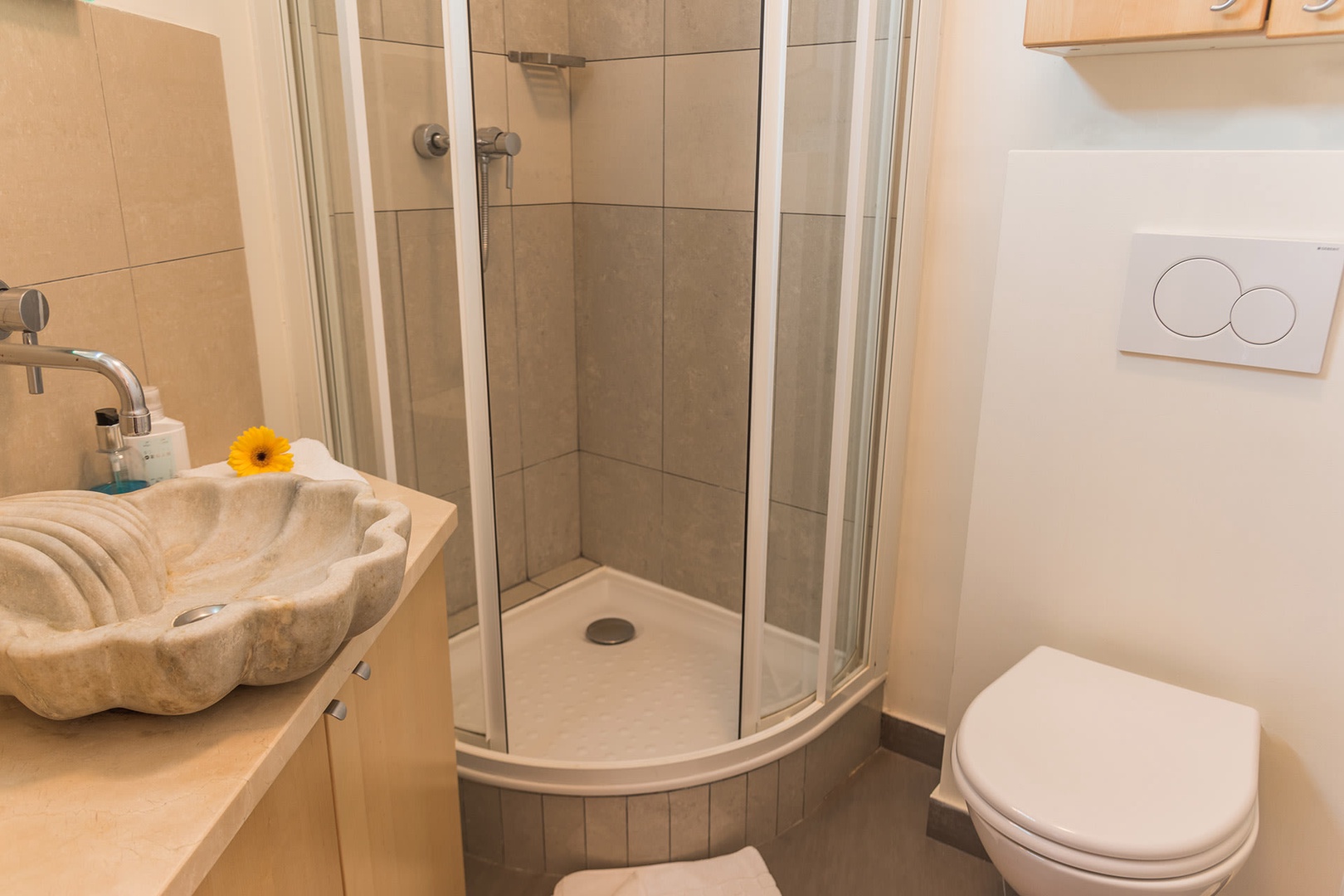 The modern bathroom features a shower, toilet and sink.