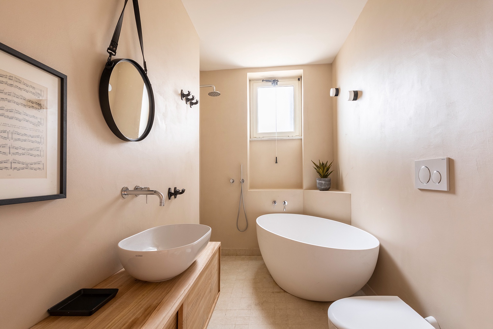 Two modern bathrooms, bathroom 1 has a bathtub and open shower.