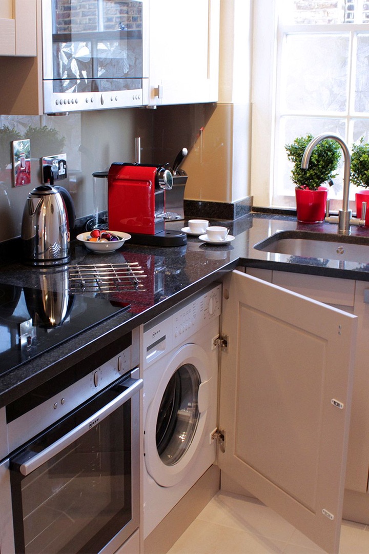 Open cupboard in kitchen to find the washing machine