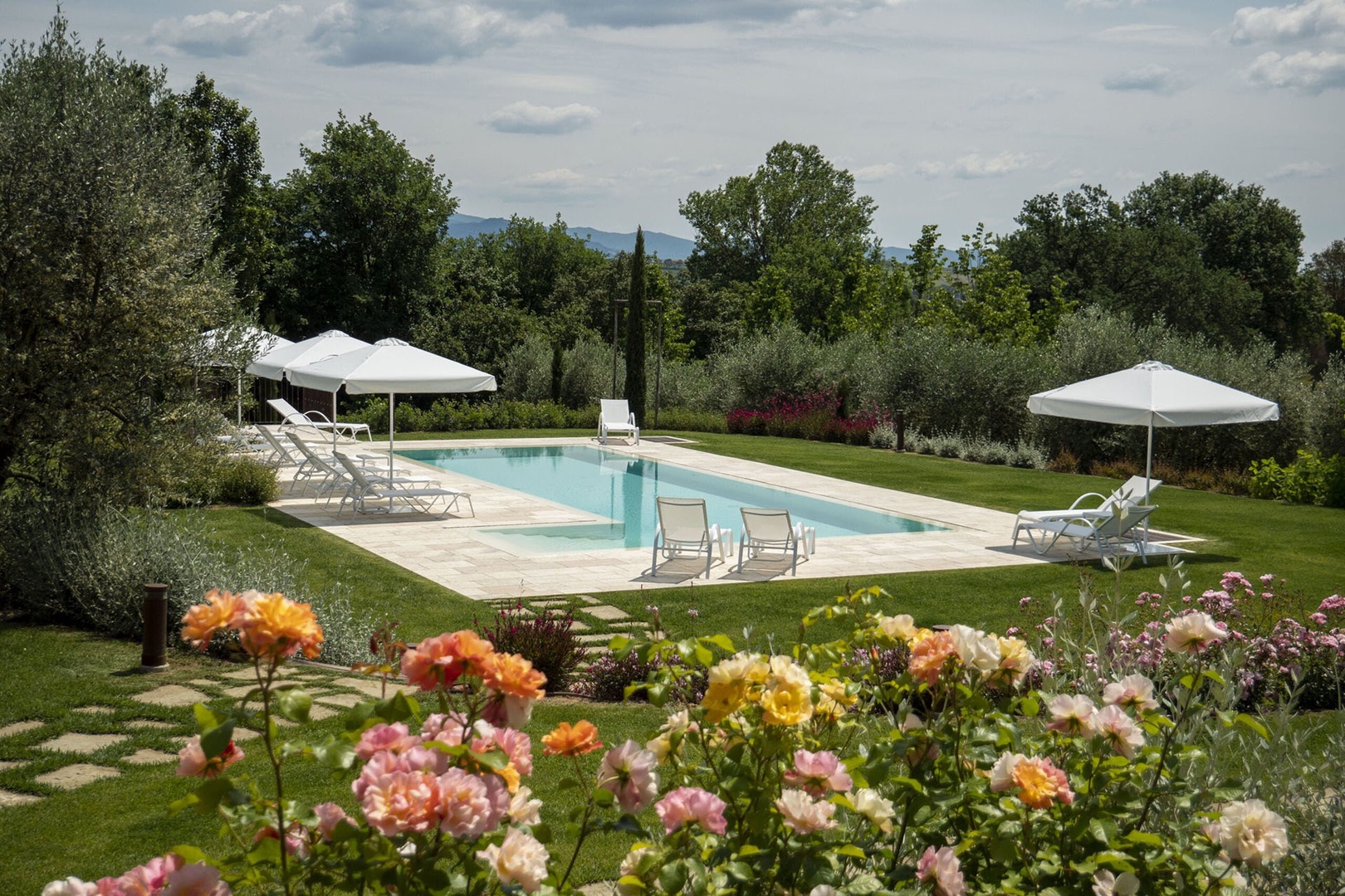 Stunning pool with lounge chairs and umbrellas.