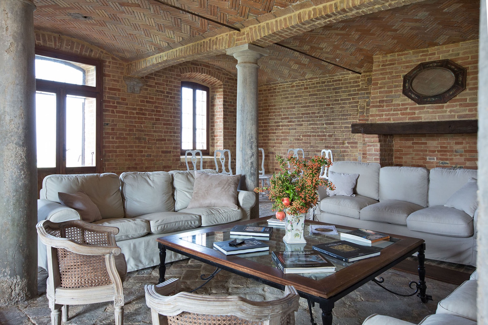 The spacious living room with brick arches and stone columns and lots of seating