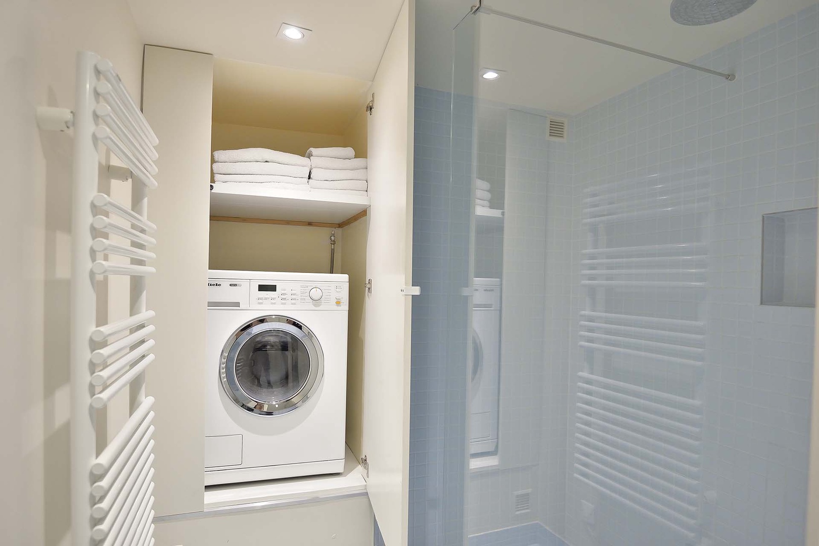 Large shower and washer/dryer combo in bathroom.