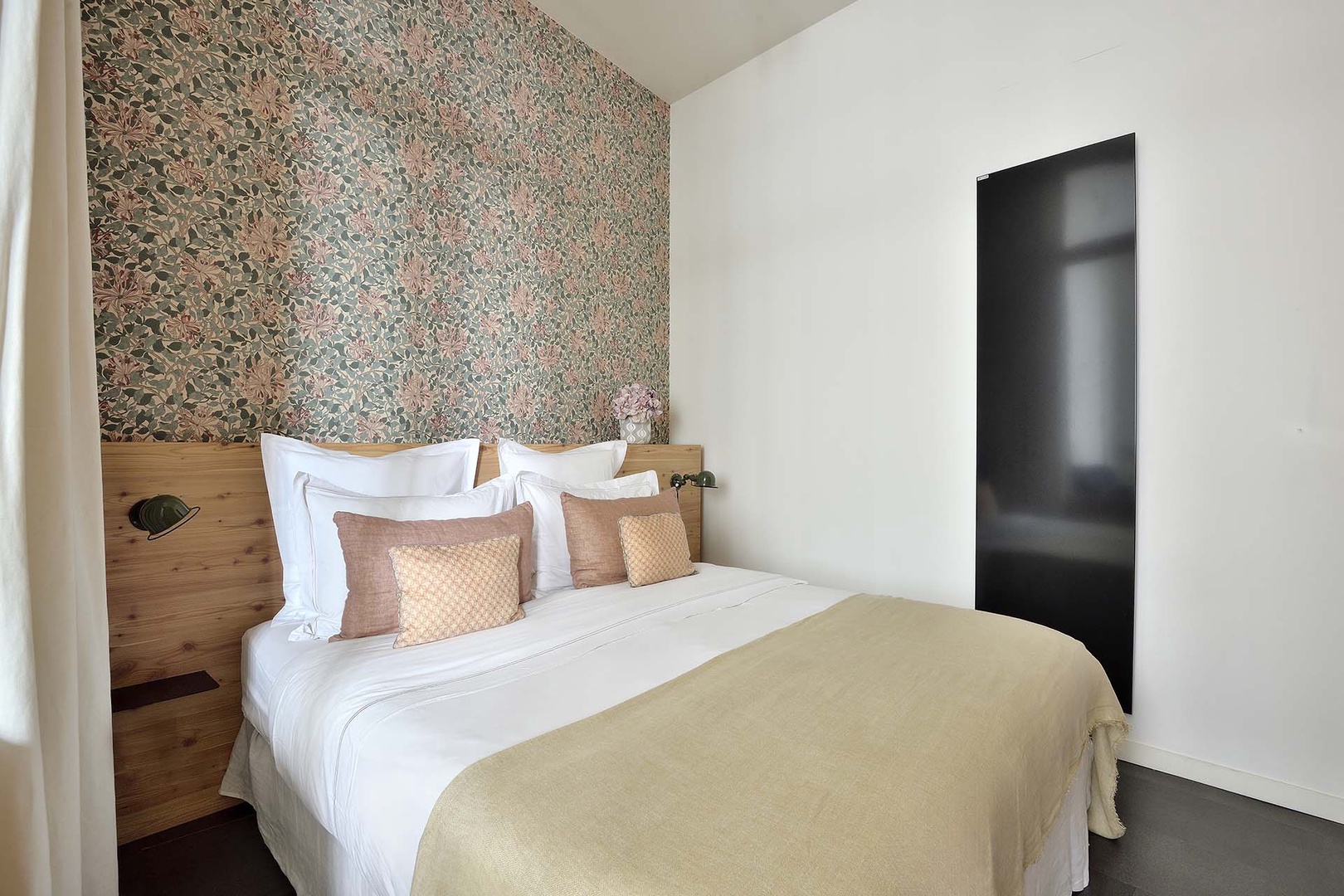Light fills the bedroom through glass wall.