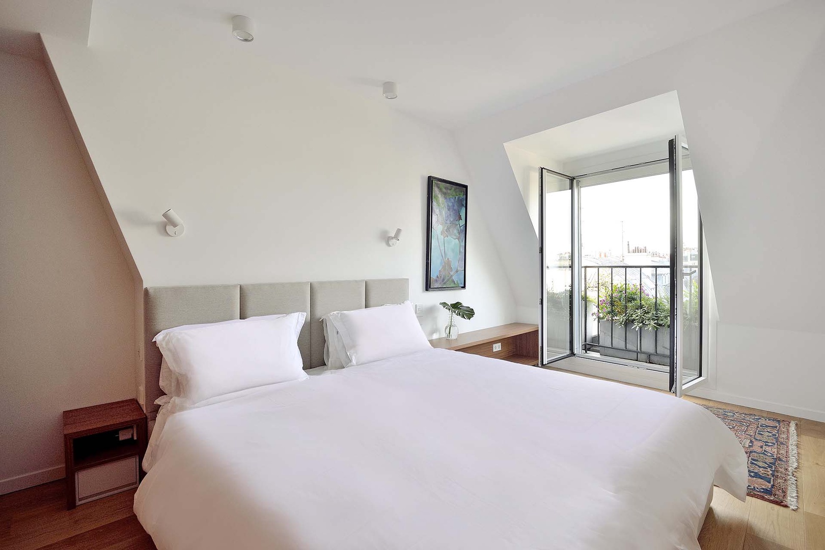 Serene bedroom with views of Paris from the balcony.