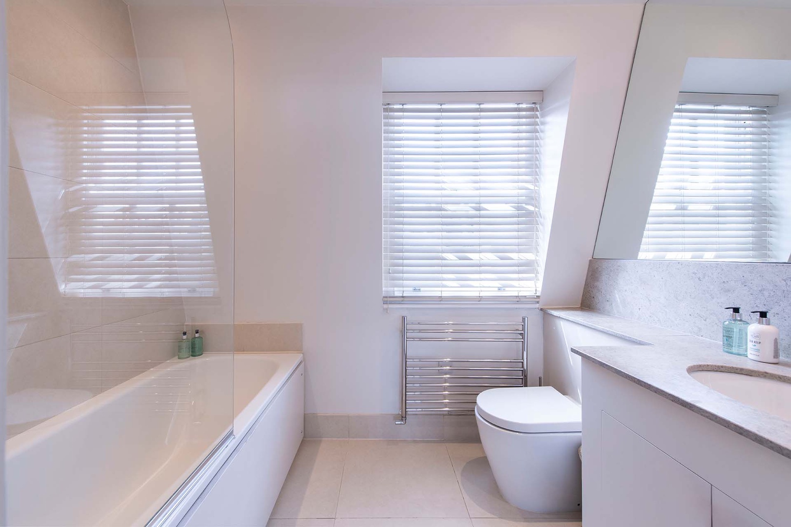 En suite has a combo bathtub/shower, toilet and sink.