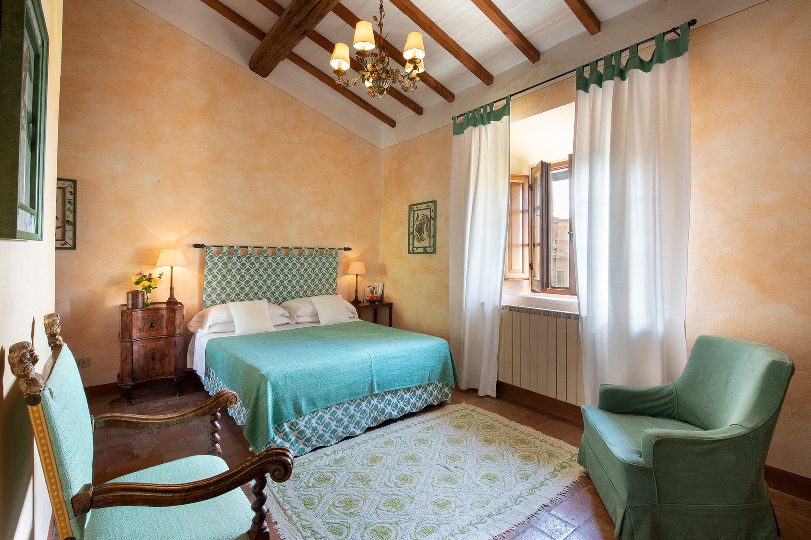 High beamed ceiling in bedroom 1 with windows overlooking the garden and orchards.