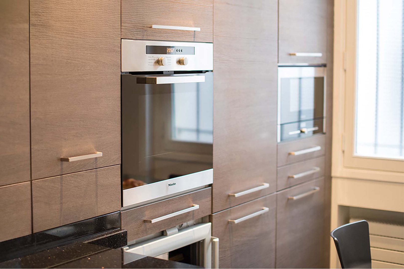 High-end oven, microwave, fridge and wine fridge are built into the kitchen design.