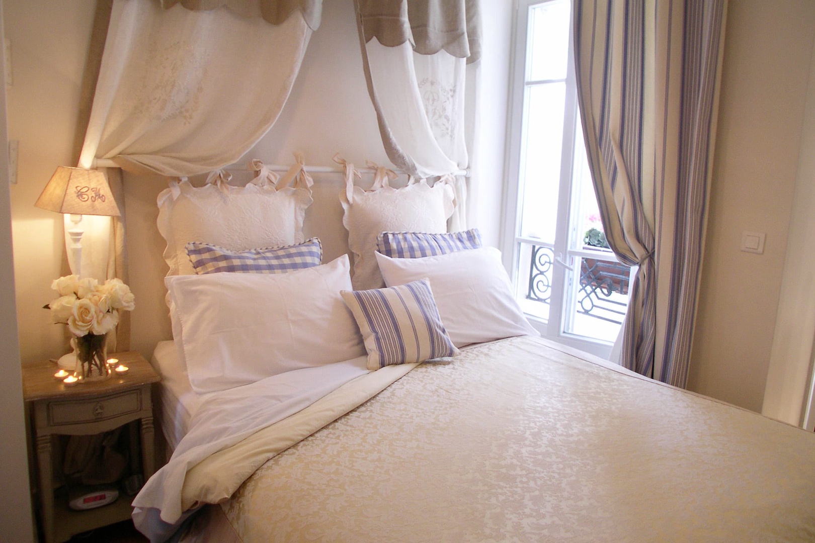 The bedroom has a beautiful bed with a romantic antique French pelmet.