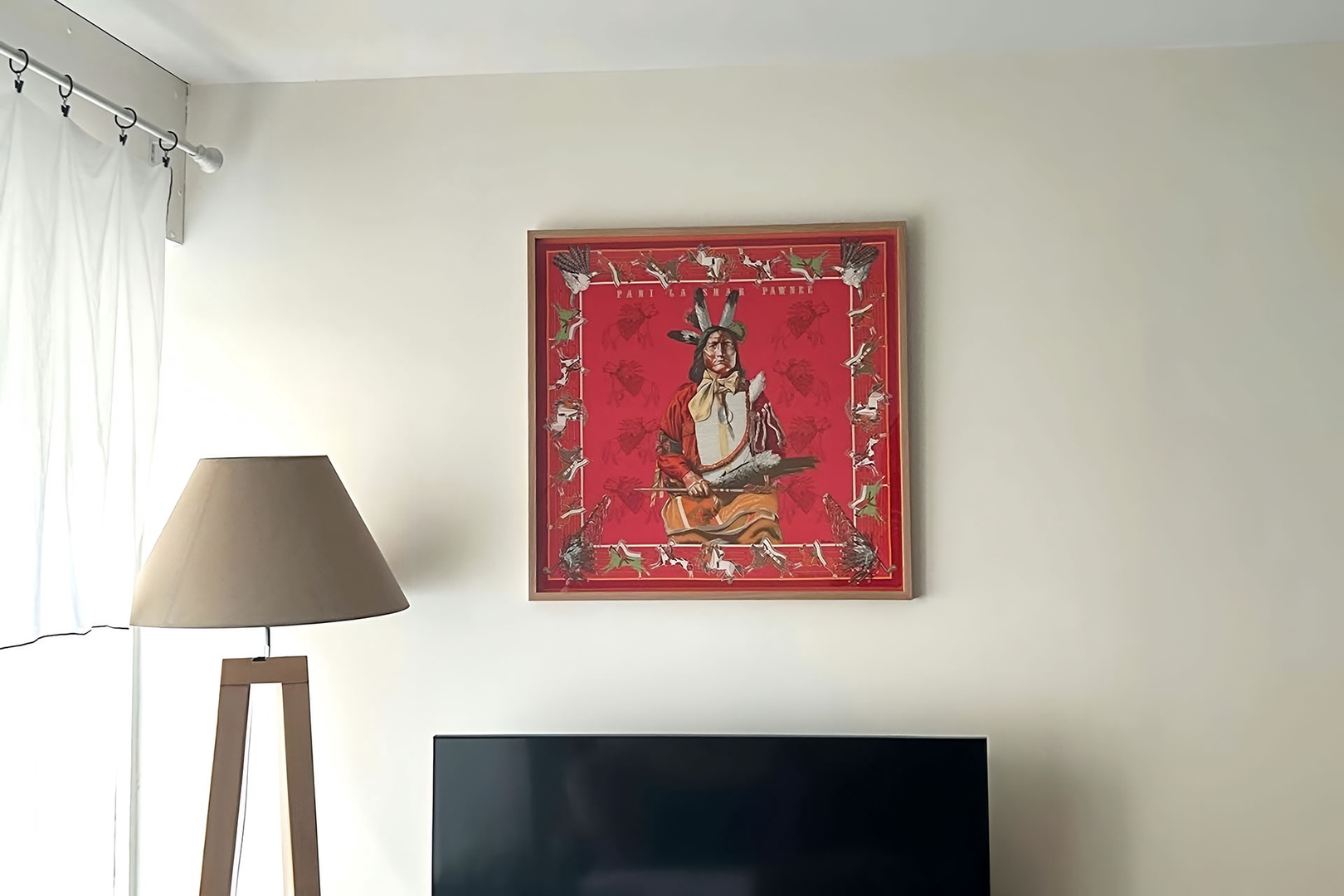 Hermès scarf "Pani La Shar Pawnee" hangs above the TV in the living room.