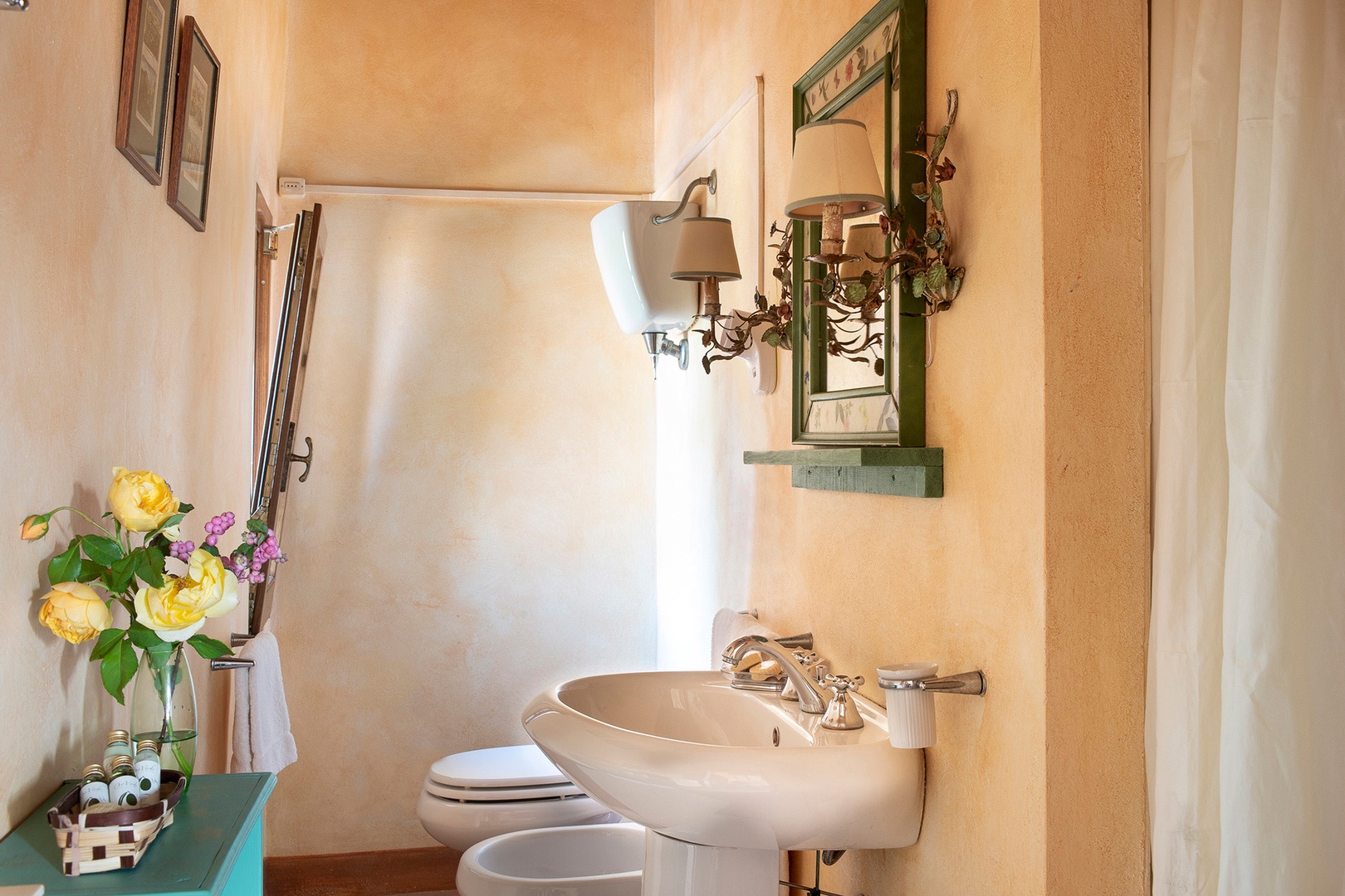 En suite bathroom has a shower, sink, toilet,  bidet, and nice courtyard view.