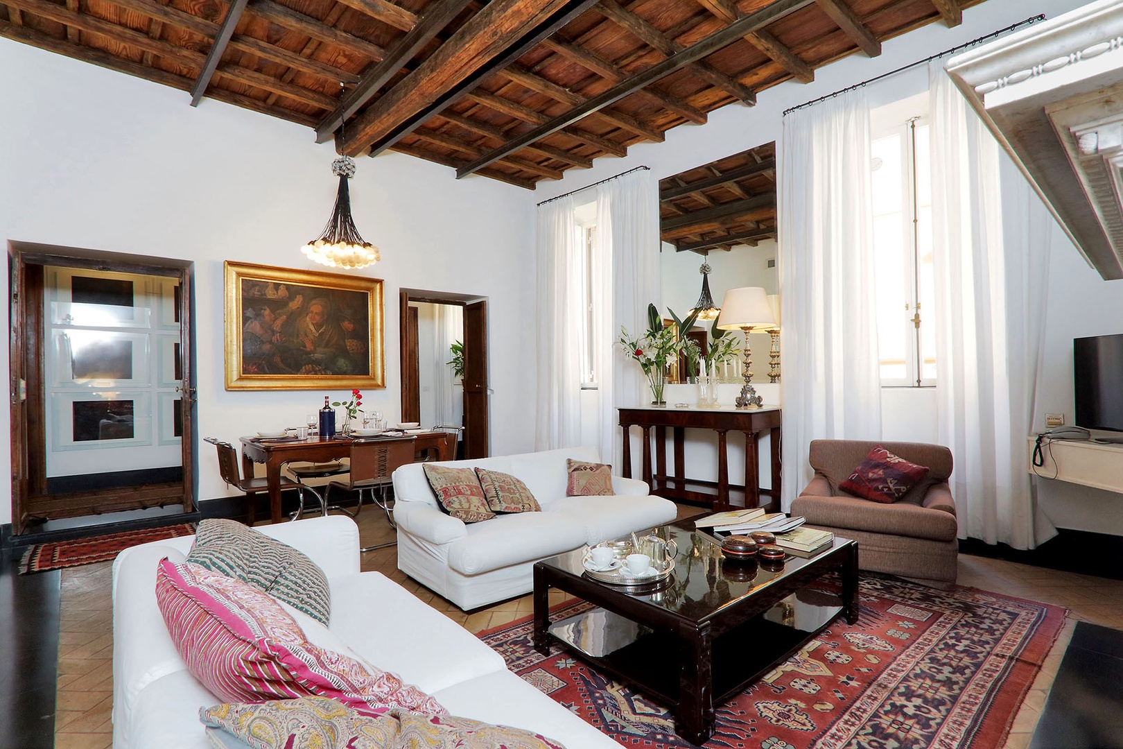 Living room 2 is filled with light from two large windows which overlook Via Bocca di Leone.