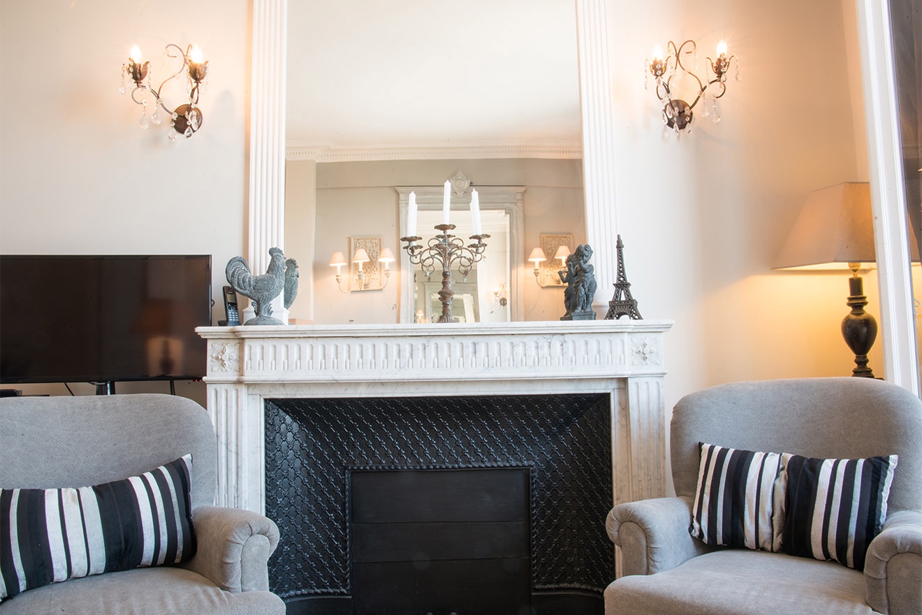 The marble fireplace adds warmth and luxury to the living room.