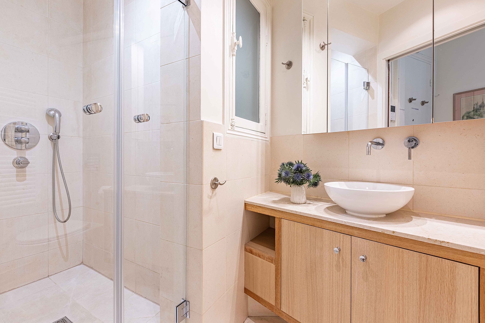 Glass shower with modern fixtures.