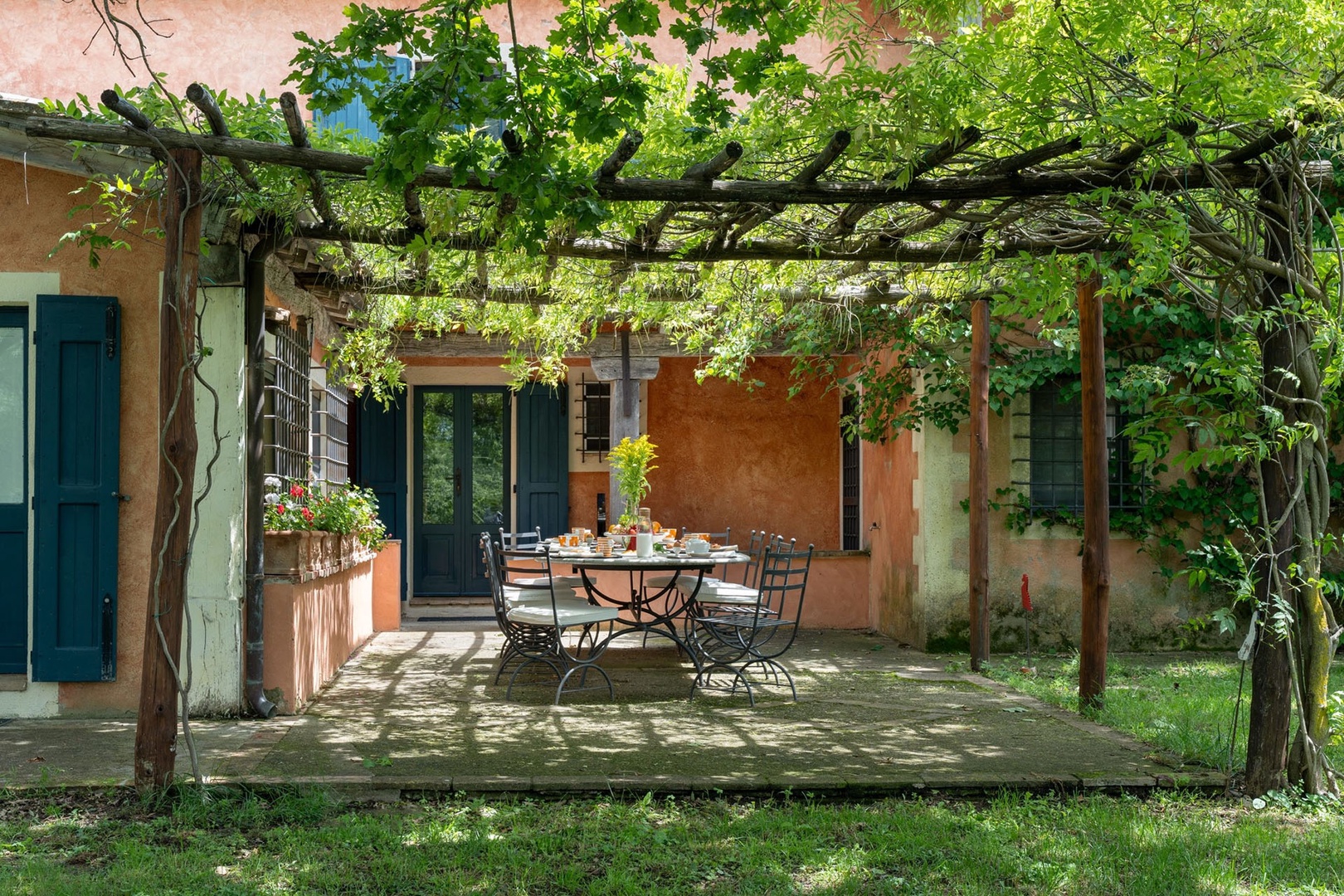Dine el fresco under the pergola shaded with wisteria
