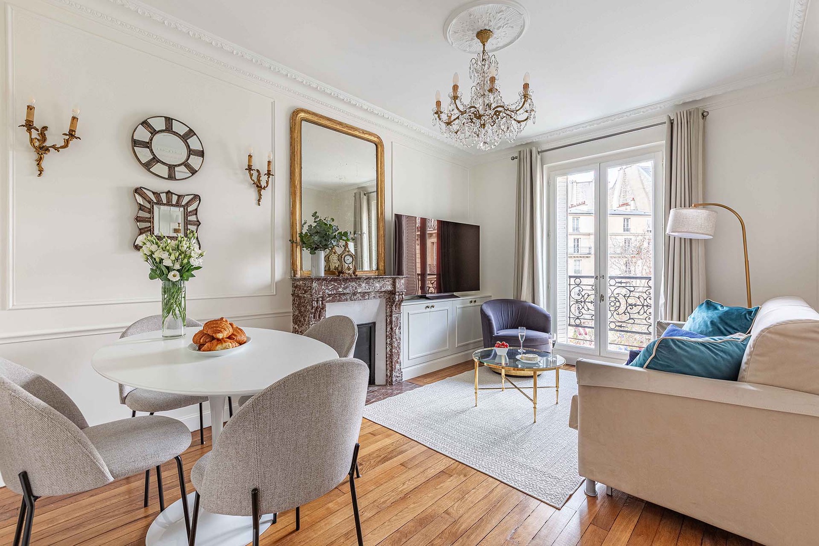 Relax in the elegant Parisian living room with plush seating, and charming city views through French doors.
