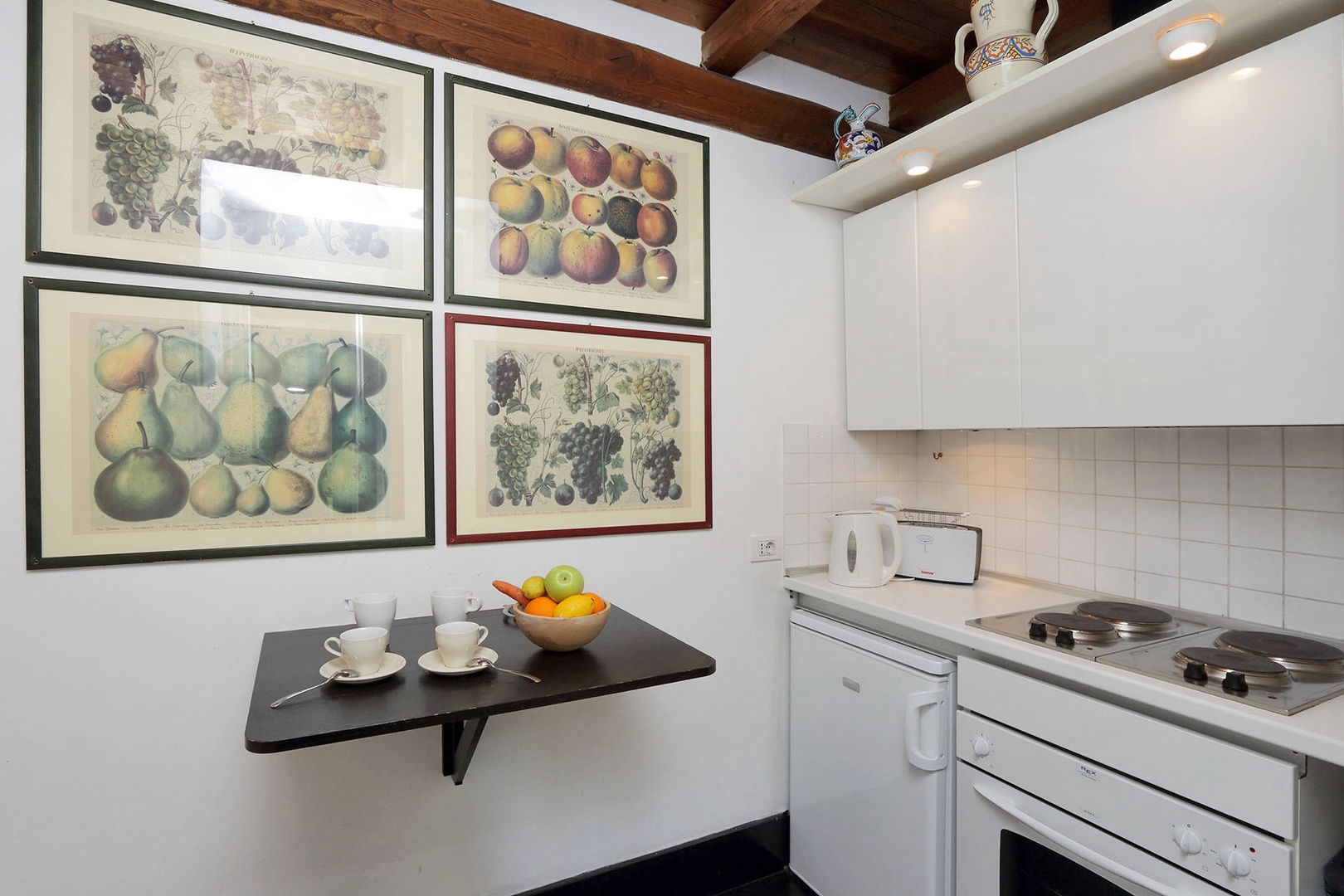 The well-lit, galley style kitchen has the sink and dishwasher with cabinets above on one side.