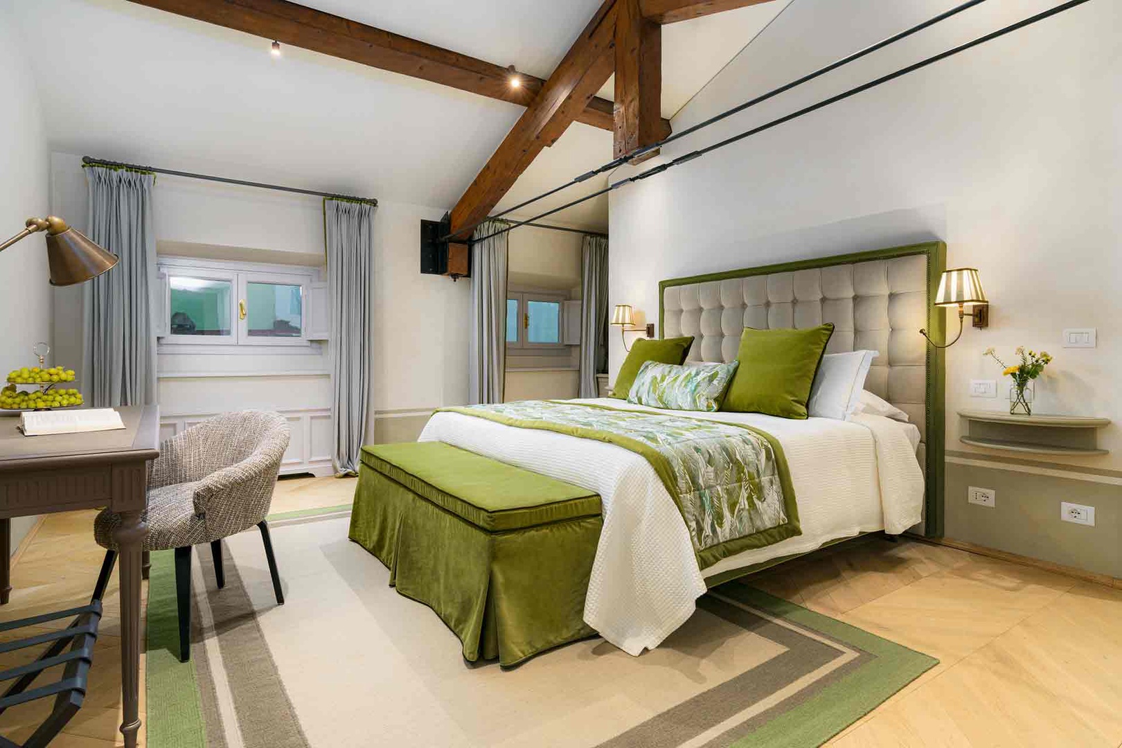 Beautifully appointed bedroom 1 with rustic wood beams.