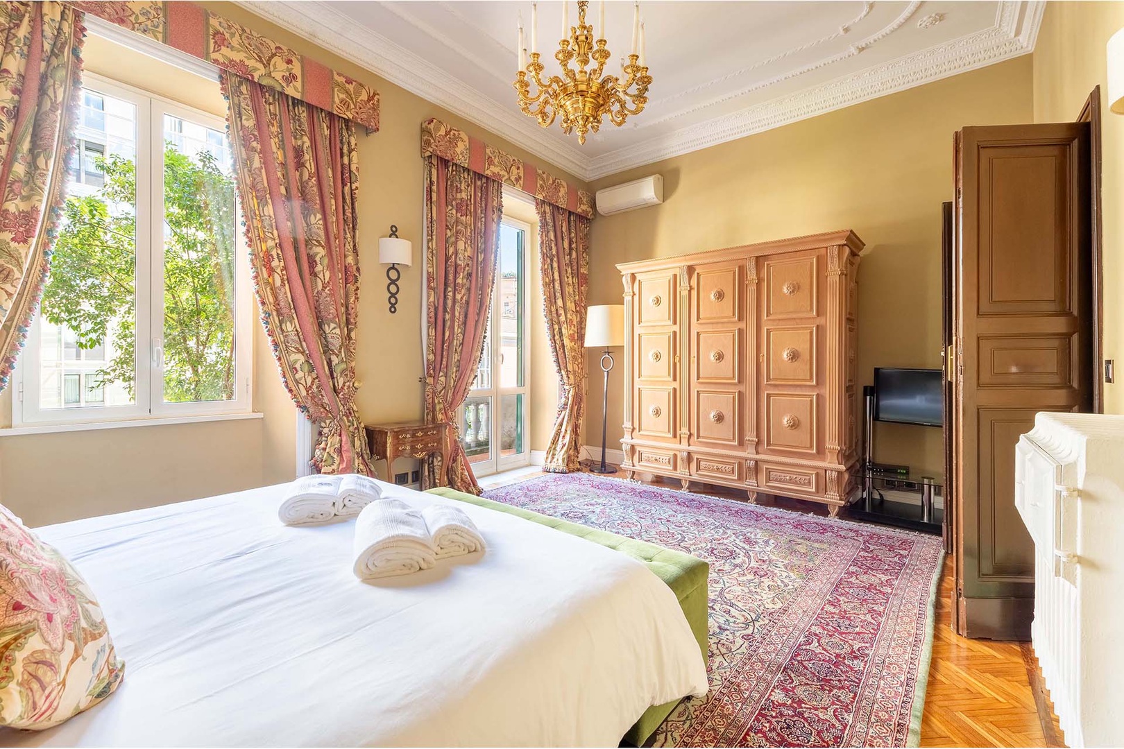 Bedroom 1 is spacious with French doors leading out to a narrow balcony.