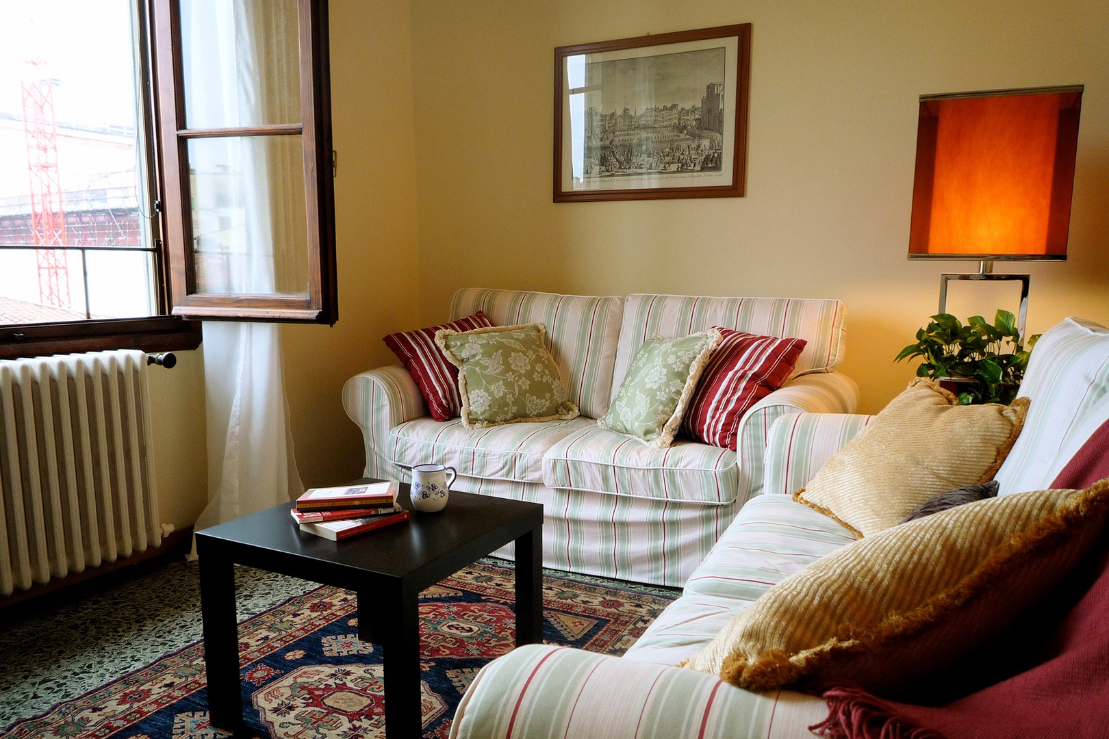 Large living room window admits lots of light. Original polished terrazzo floors.