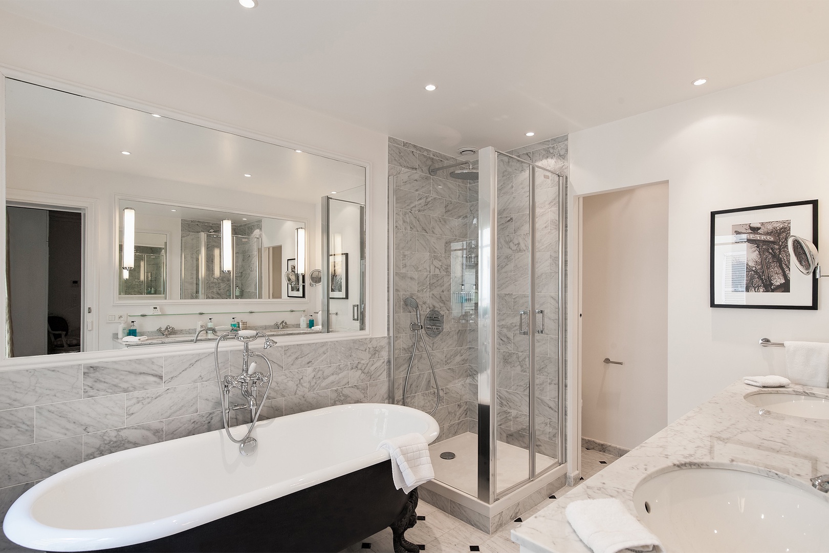 The en suite bathroom 1 is a glistening setting of gray marble.