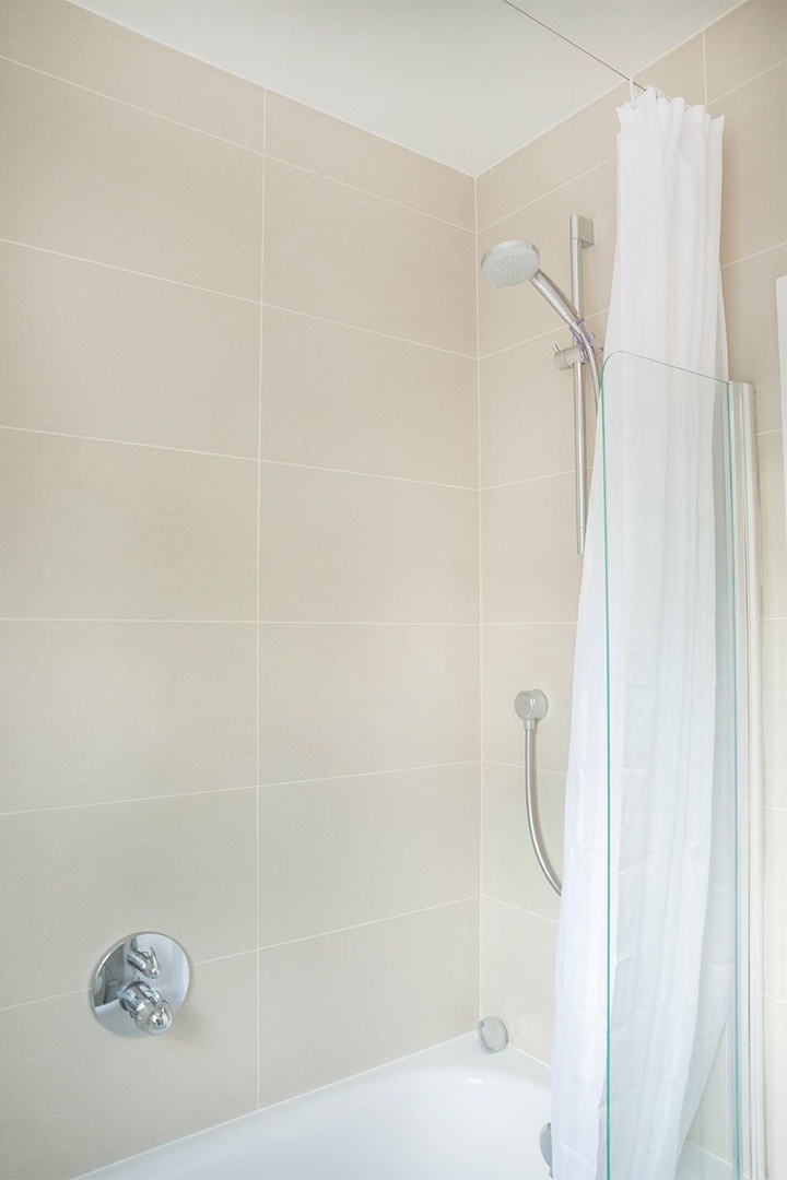 Bathtub and shower combo in the bathroom.